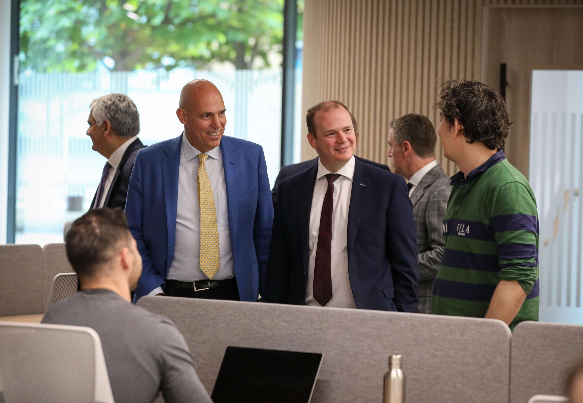The Northern Ireland Finance Minister (center) visiting the TBOL NI Office and talking with COO Jim (left) and Senior Software Engineer Pieter (right)